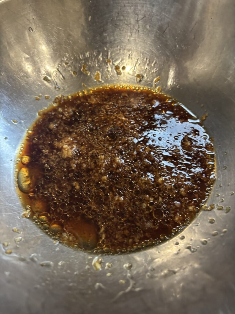 To Mix the garlic and ginger, the soy sauce, cooking sake, and sesame oil.